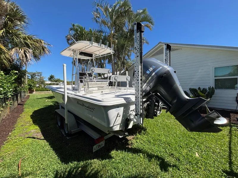 Slide: The Image of 2013 SeaHunter 24 Bay boat on trailer, parked on grass beside a house. - 6