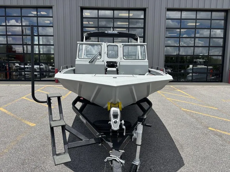 Slide: The Image of 2026 SeaArk ProCat 240 boat on trailer, parked outside a building with glass doors. - 12