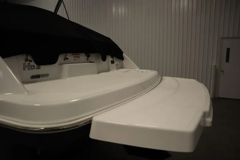 Slide: The Image of 2025 Four Winns HD3 boat with covered deck in a storage facility. - 47