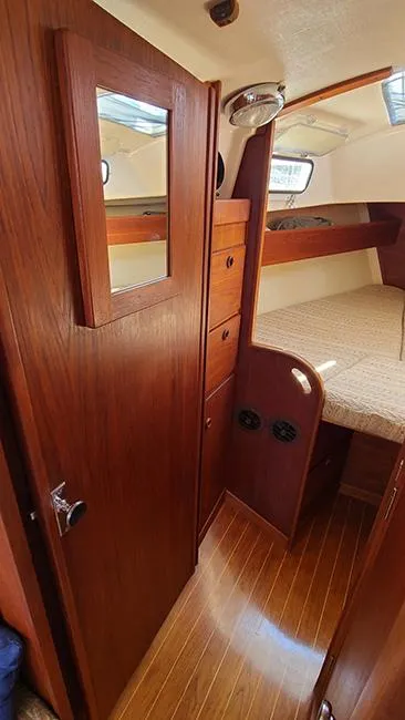 Slide: The Image of 1983 Sabre 34 yacht interior with wooden cabinetry and cozy sleeping area. - 15