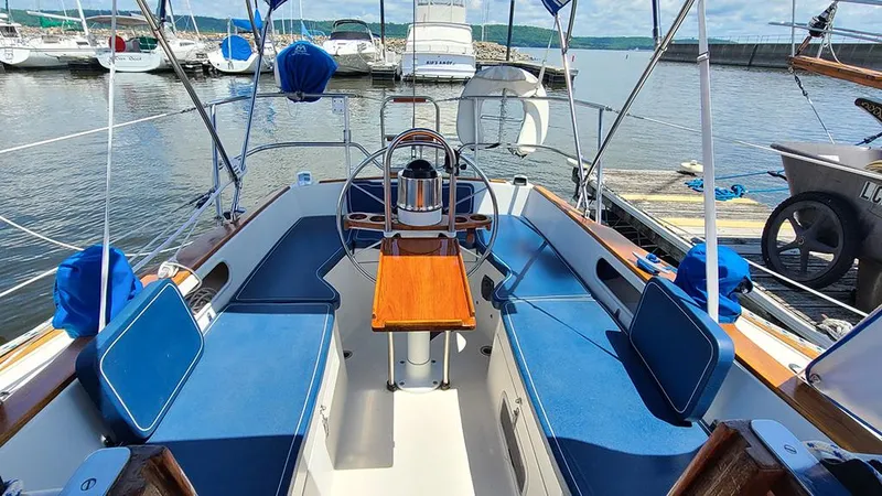 Slide: The Image of 1983 Sabre 34 sailboat cockpit with blue seating, docked at marina. - 16