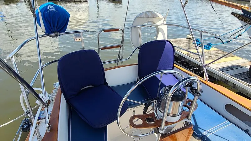 Slide: The Image of Cockpit of 1983 Sabre 34 sailboat with blue cushioned seats and steering wheel. - 18