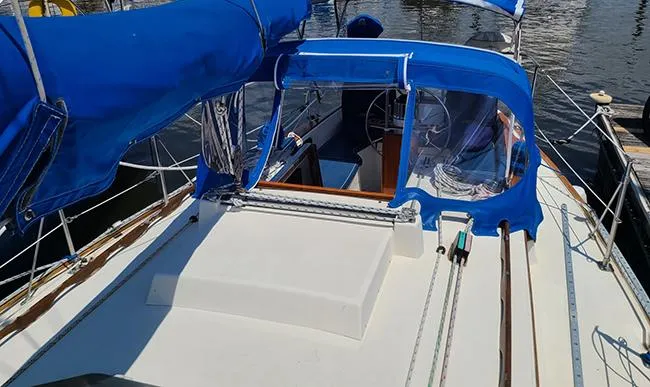 Slide: The Image of 1983 Sabre 34 sailboat with blue canvas cover and visible cockpit area. - 20