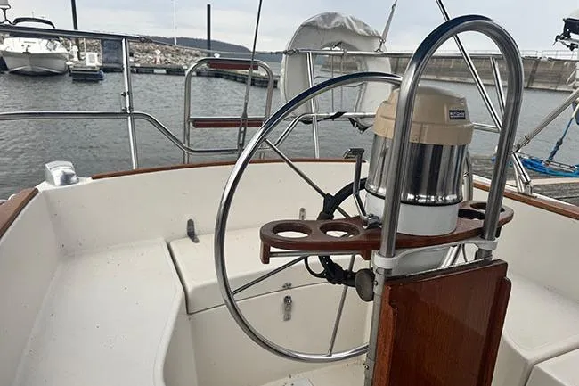 Slide: The Image of Cockpit of 1983 Sabre 34 sailboat with steering wheel and marina view. - 22