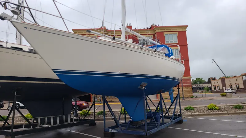 Slide: The Image of 1983 Sabre 34 sailboat on a stand, with a blue hull, in a parking lot. - 4