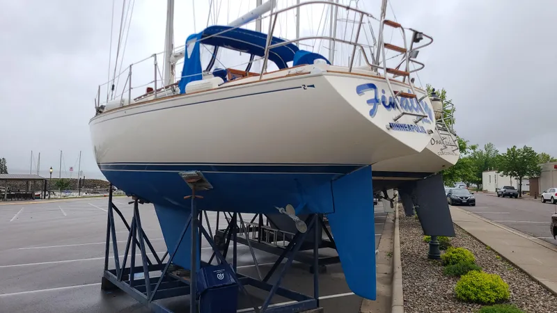 Slide: The Image of 1983 Sabre 34 sailboat on stands in a parking lot, overcast sky. - 5