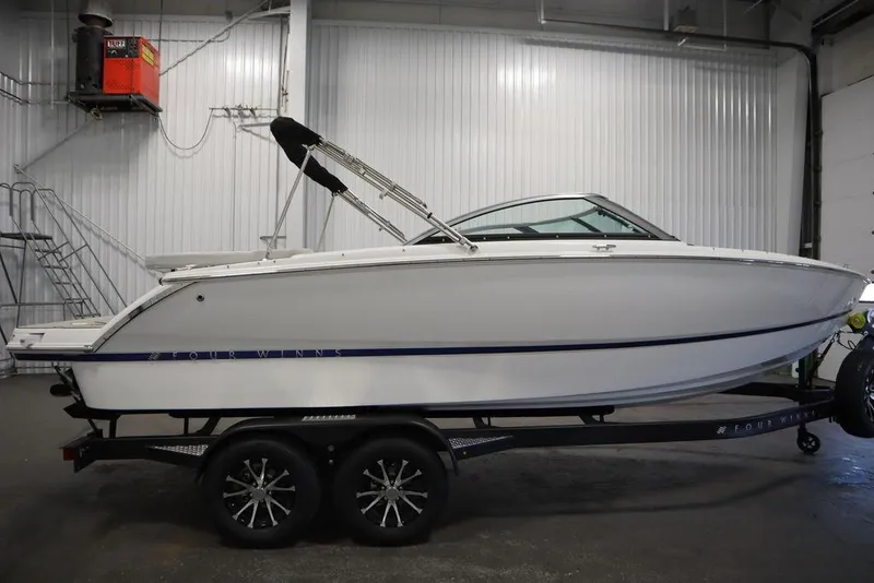 Slide: The Image of 2025 Four Winns H2 Freedom boat on trailer in indoor storage. - 1