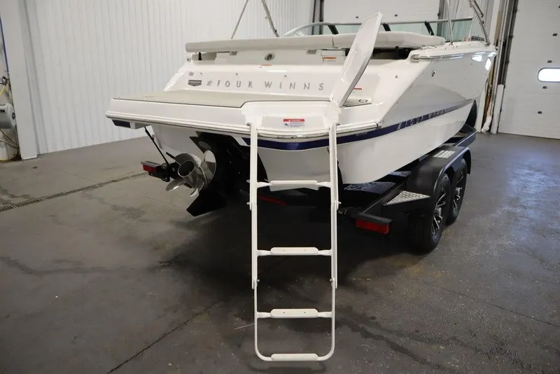 Slide: The Image of 2025 Four Winns H2 Freedom boat on trailer with ladder in a garage. - 16
