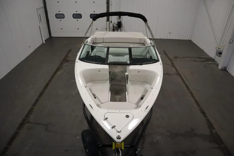 Slide: The Image of 2025 Four Winns H2 Freedom boat in indoor storage, showcasing sleek design and spacious seating. - 19