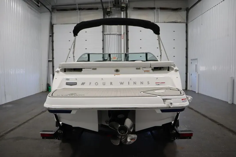 Slide: The Image of 2025 Four Winns H2 Freedom boat in a garage, rear view. - 2