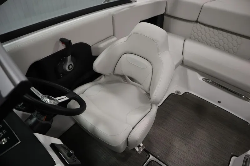 Slide: The Image of 2025 Four Winns H2 Freedom boat interior with white seating and steering wheel. - 25