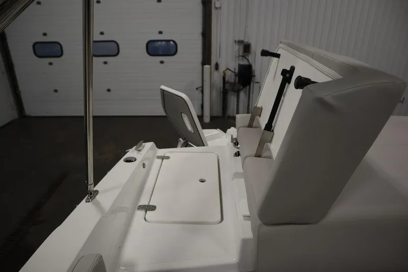 Slide: The Image of 2025 Four Winns H2 Freedom boat interior with cushioned seating and storage compartment. - 49