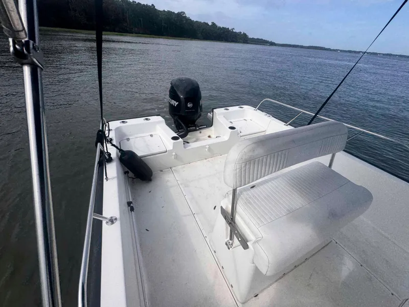 Slide: The Image of 2014 Boston Whaler 210 Montauk boat on calm water, featuring a Mercury outboard motor. - 14