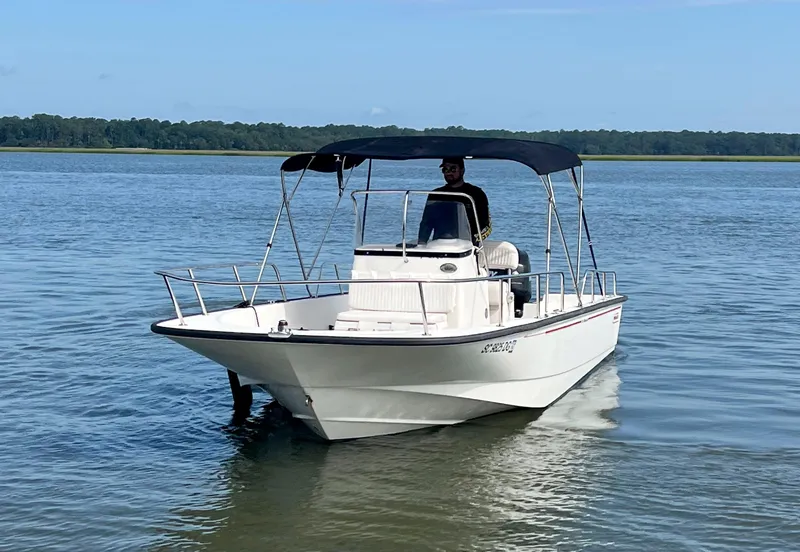 Slide: The Image of 2014 Boston Whaler 210 Montauk boat on calm water with canopy. - 2