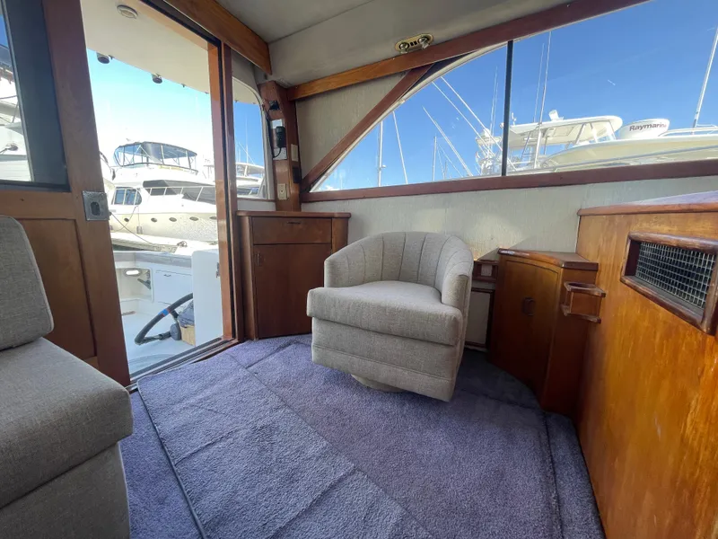 Slide: The Image of Interior of 1989 Ocean Yachts 35 Super Sport, featuring wooden cabinetry and compact kitchen area. - 9