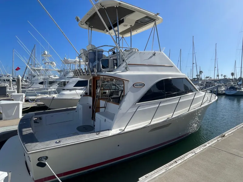 Slide: The Image of 1989 Ocean Yachts 35 Super Sport docked at marina under clear blue sky. - 1