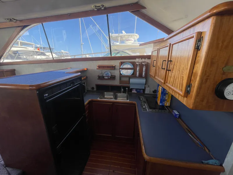 Slide: The Image of 1989 Ocean Yachts 35 Super Sport kitchen with fridge, microwave, and wooden cabinetry. - 10