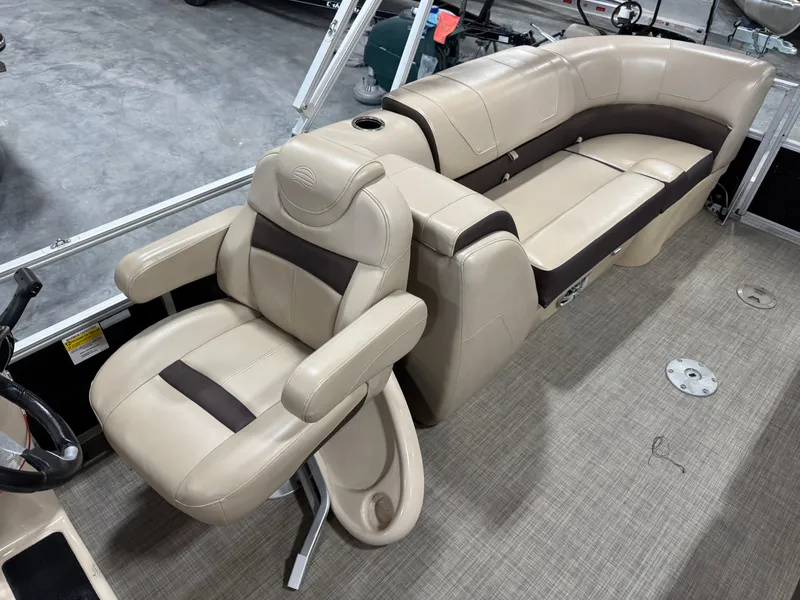 Slide: The Image of 2018 Sun Tracker Party Barge 24 DLX XP3 interior with beige seating and steering console. - 10