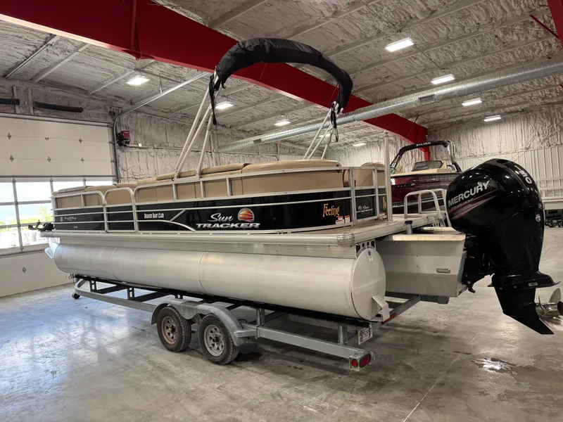 Slide: The Image of 2018 Sun Tracker Party Barge 24 DLX XP3 pontoon boat in a spacious indoor facility. - 4