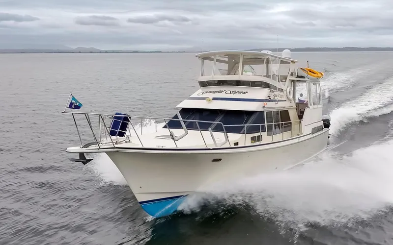 Slide: The Image of 1990 Tollycraft 44 Cockpit Motor Yacht cruising on open water. - 1