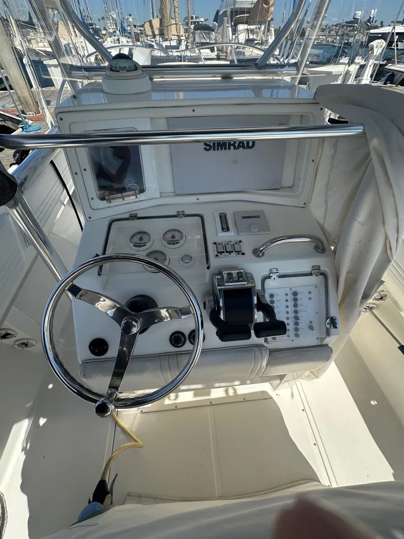 Slide: The Image of 2004 Fountain 31 Tournament Edition boat dashboard with steering wheel and Simrad navigation system. - 8