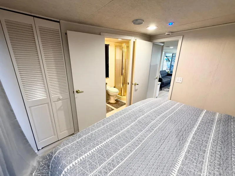 Slide: The Image of Interior of 1995 Skipperliner 52 Yacht featuring bedroom, bathroom, and closet. - 13
