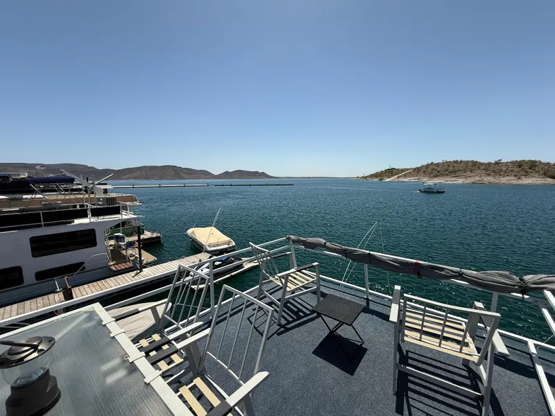 Slide: The Image of 1995 Skipperliner 52 Inter-Coastal Motor Yacht docked on a serene lake with clear skies. - 24