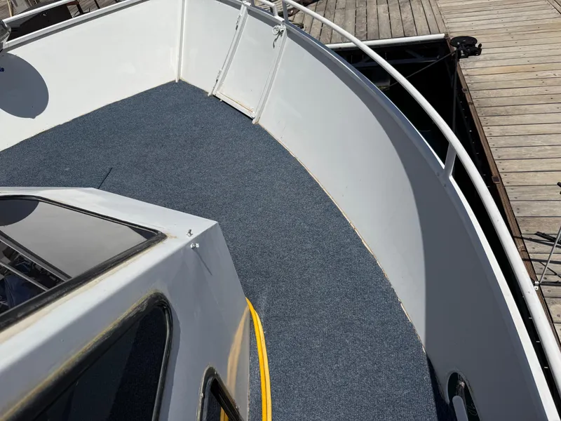 Slide: The Image of 1995 Skipperliner 52 Inter-Coastal Motor Yacht HB deck with blue carpet and dock view. - 34