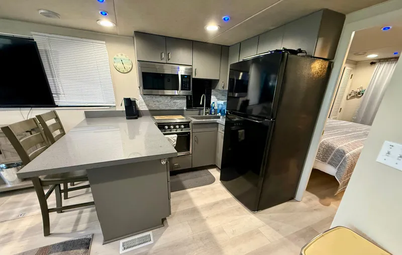 Slide: The Image of Modern kitchen in a 1995 Skipperliner 52 Inter-Coastal Motor Yacht, featuring sleek appliances and dining area. - 5