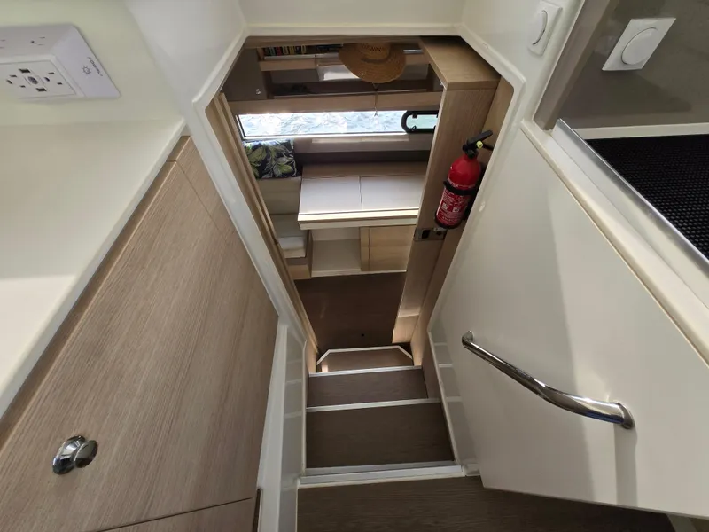 Slide: The Image of Interior of 2018 Bali 4.1 Catamaran, featuring stairs, wooden cabinets, and a fire extinguisher. - 16