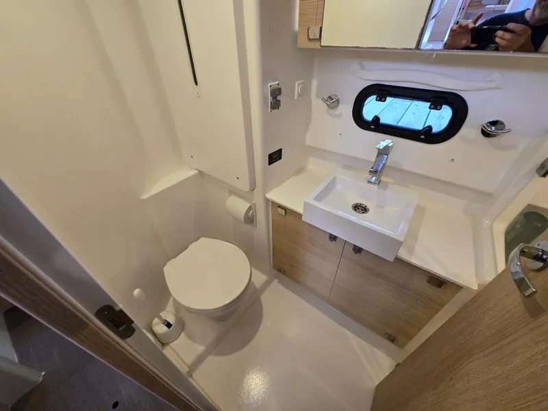 Slide: The Image of Bathroom interior of 2018 Bali 4.1 Catamaran with sink, toilet, and porthole window. - 23