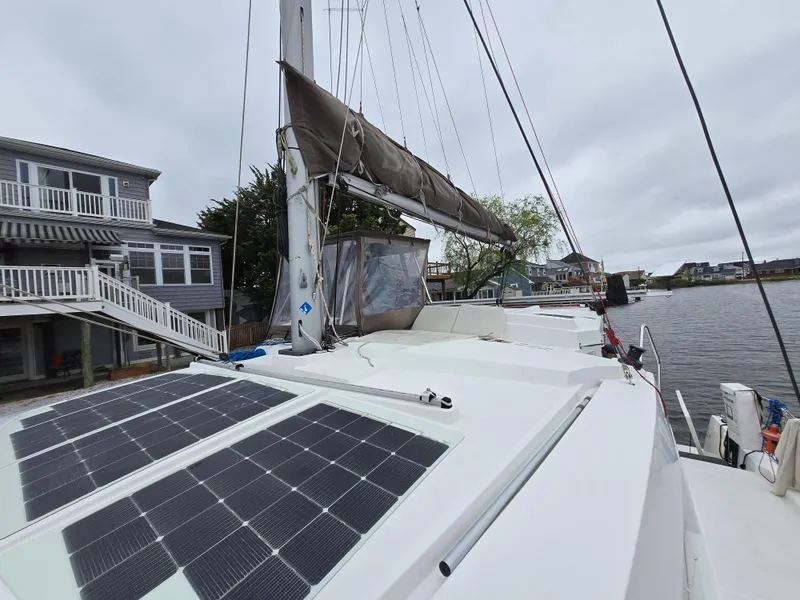 Slide: The Image of 2018 Bali 4.1 Catamaran with solar panels docked near waterfront homes. - 28