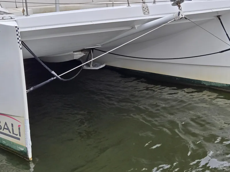 Slide: The Image of Bali 4.1 Catamaran 2018, close-up of hull and water reflection. - 38