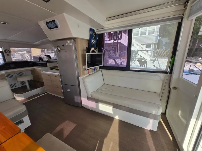 Slide: The Image of Interior of 2018 Bali 4.1 Catamaran with seating, fridge, and window view. - 43