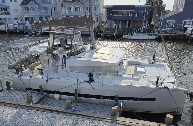 Slide: The Image of 2018 Bali 4.1 Catamaran docked by waterfront homes. - 5