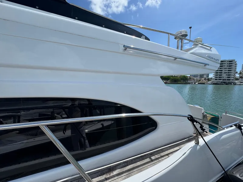 Slide: The Image of 1997 Azimut 54 yacht docked by waterfront, showcasing sleek design and modern architecture. - 26