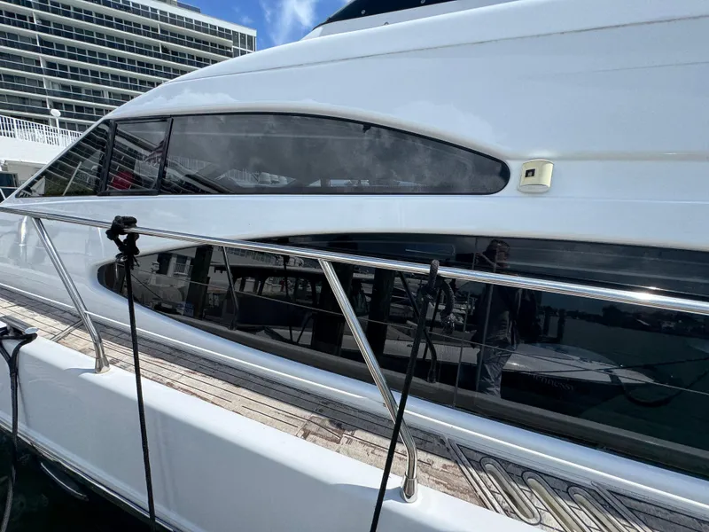 Slide: The Image of 1997 Azimut 54 yacht docked, showcasing sleek design and reflective windows. - 27