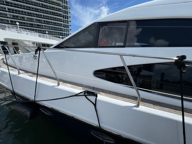Slide: The Image of Side view of a 1997 Azimut 54 yacht docked near a modern building. - 28