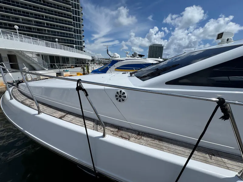 Slide: The Image of 1997 Azimut 54 yacht docked at marina, sleek design, sunny day, modern architecture backdrop. - 29