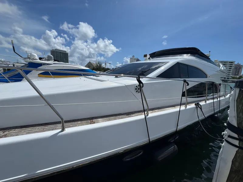 Slide: The Image of 1997 Azimut 54 yacht docked under a clear blue sky. - 32