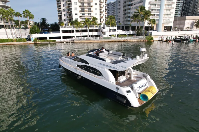 Slide: The Image of Luxury 1997 Azimut 54 yacht cruising near waterfront buildings and palm trees. - 4