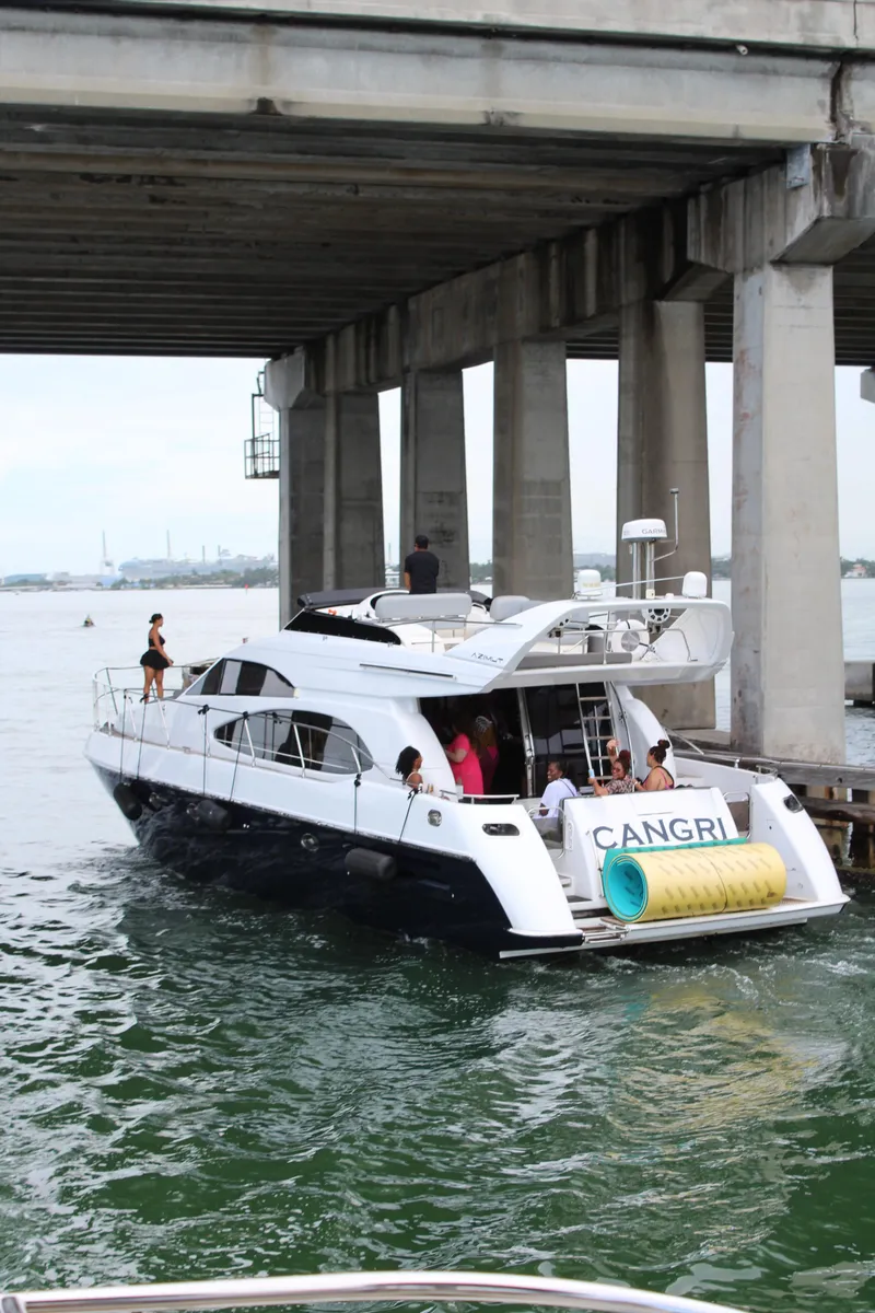Slide: The Image of Azimut 54 yacht from 1997 navigating under a bridge with passengers onboard. - 5