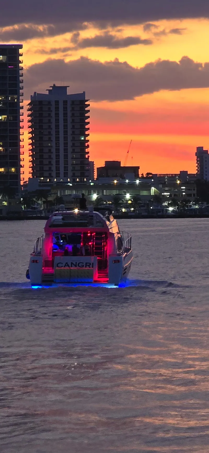 Slide: The Image of Azimut 54 yacht cruising at sunset with city skyline in the background. - 8