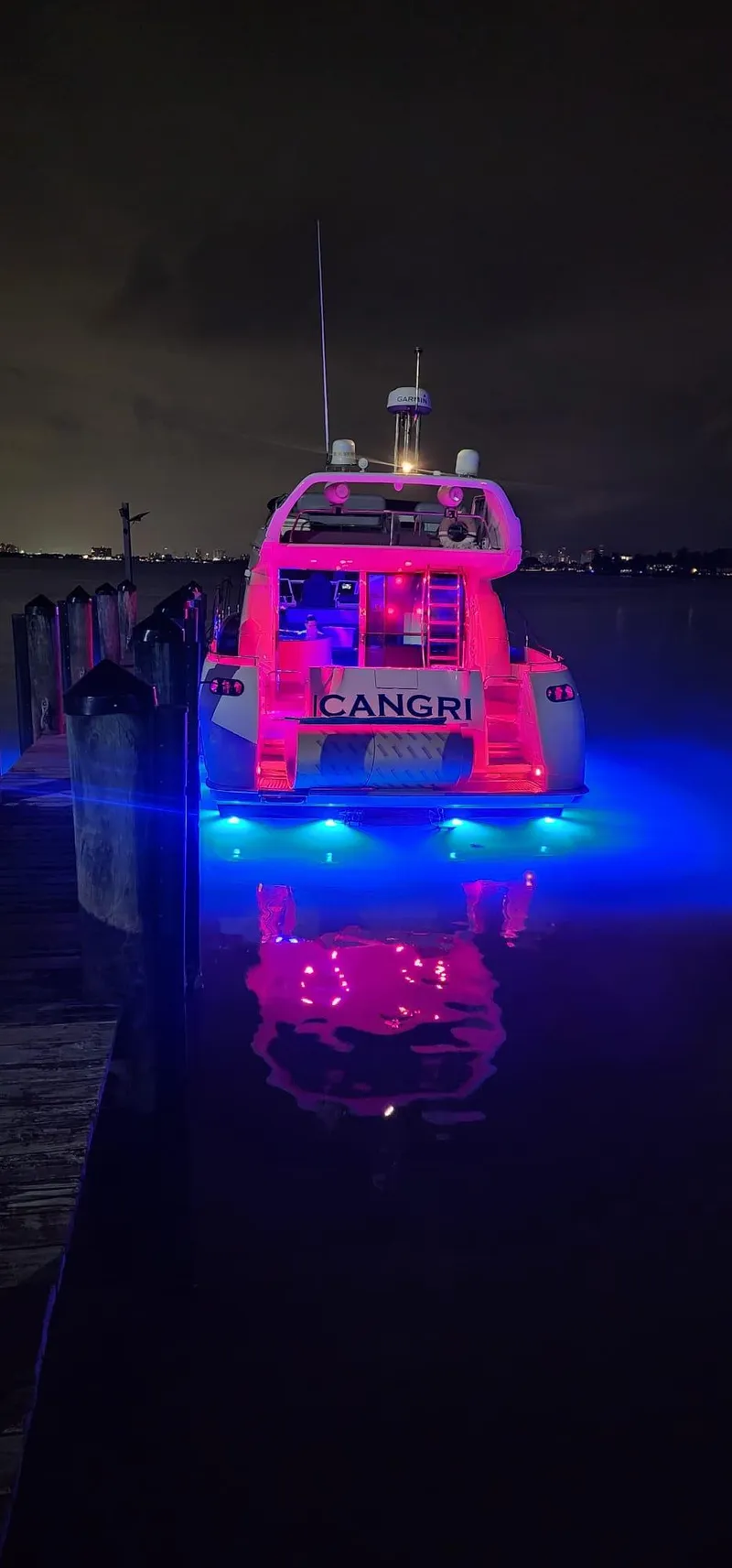 Slide: The Image of Azimut 54 yacht, 1997 model, illuminated with vibrant red and blue lights at night. - 9