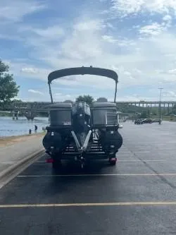 Slide: The Image of 2024 Regency 250 LE3 pontoon boat parked near a scenic waterfront. - 3
