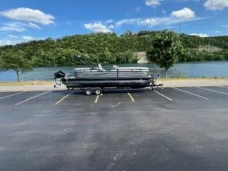 Slide: The Image of 2024 Regency 250 LE3 pontoon boat on trailer in parking lot by river. - 4
