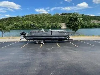 Slide: The Image of 2024 Regency 250 LE3 pontoon boat on trailer by a scenic river. - 5