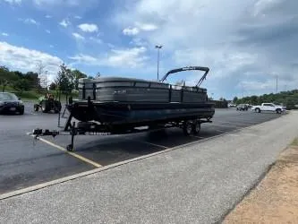 Slide: The Image of 2024 Regency 250 LE3 pontoon boat on trailer in parking lot. - 6