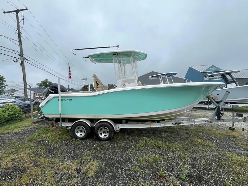 The Image of 2017 Tidewater 230 LXF boat on trailer, light blue hull, parked outdoors. - 1