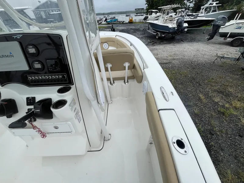 Slide: The Image of 2017 Tidewater 230 LXF boat interior with control panel and seating, parked outdoors. - 10